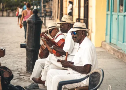 Three street musicians seated on a bench