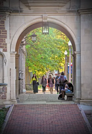 a sidewalk and archway with students