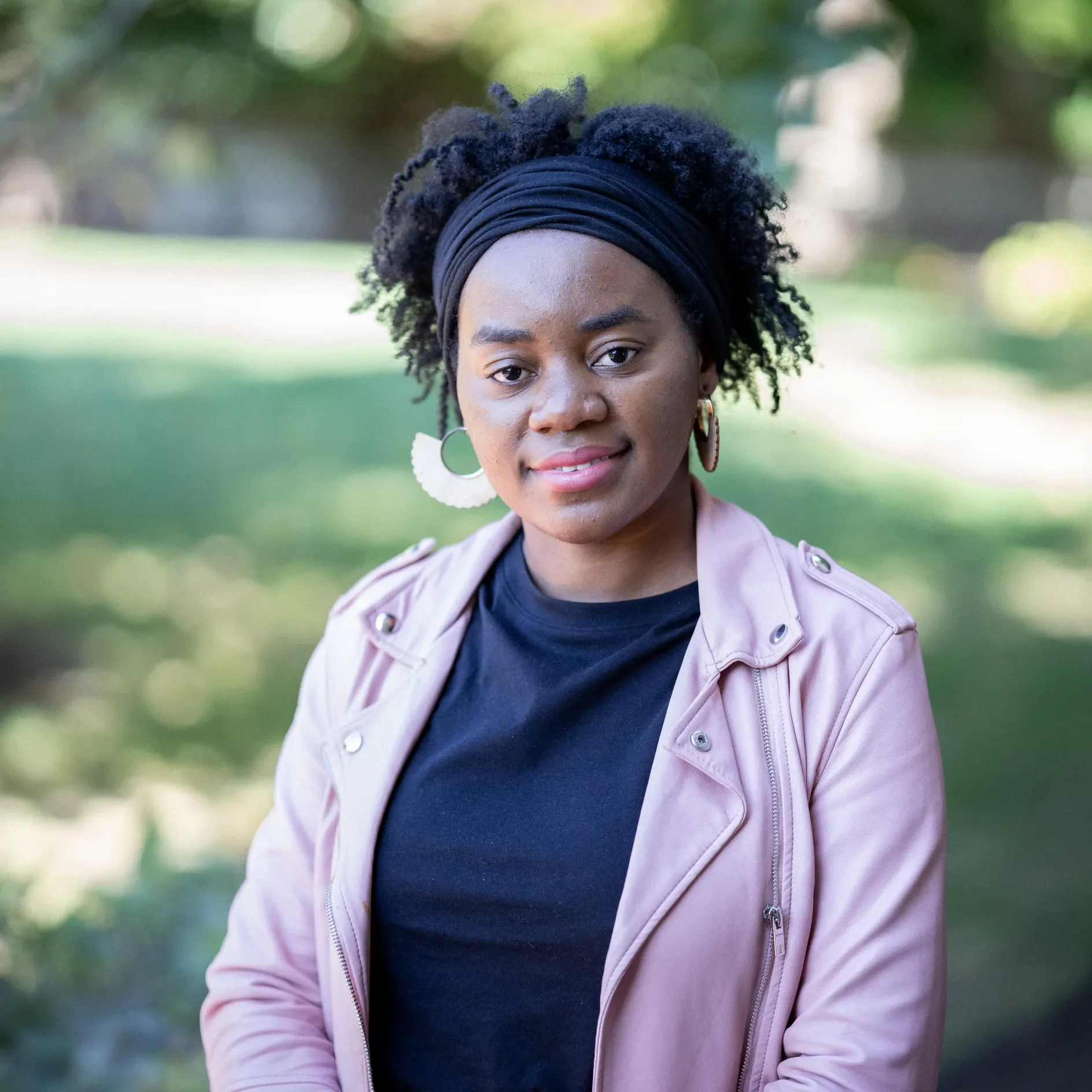 Abloom smiling to the camera in a campus background