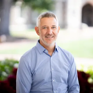 Jouane smiling at the camera with a campus background